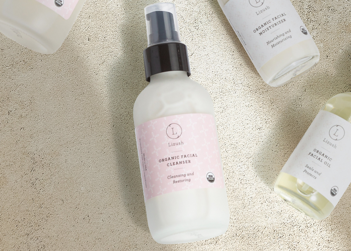 Lavender facial cleanser bottle on a pale textured surface